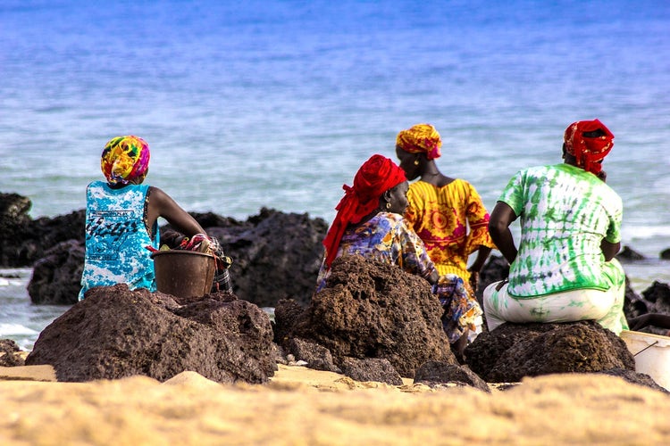 African women on a beach filling pails