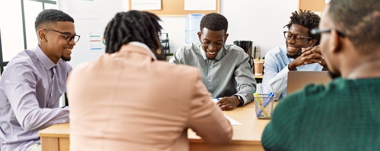 a team of people sitting around a conference room