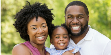 a smiling family posing for a picture in the park