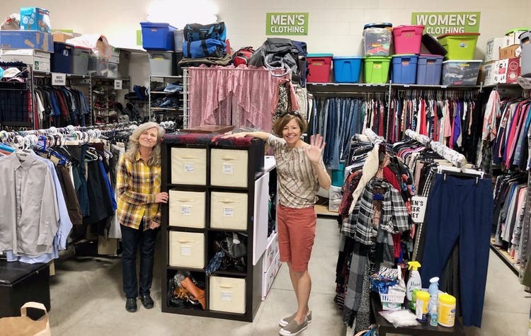 two women standing in their non-profit and posing for a photo