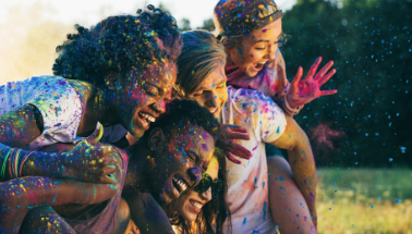a group of people getting covered in colorful paint