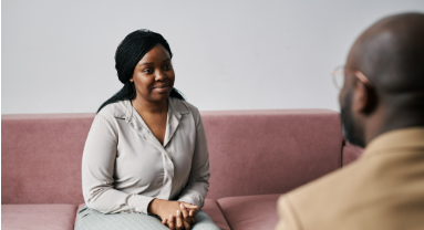 a woman sitting on the couch speaking to her therepist