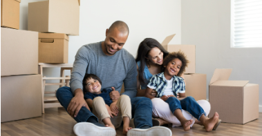 a family sitting on the floor after moving into their first home
