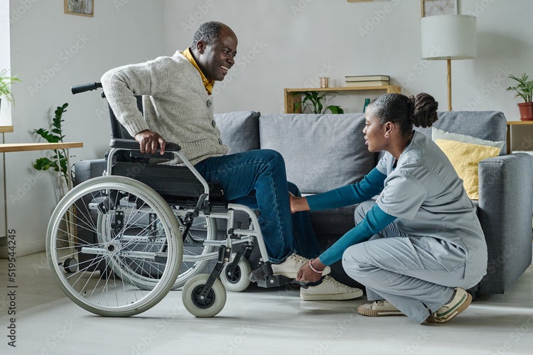 a nurse assisting her patient who is in a wheelchair